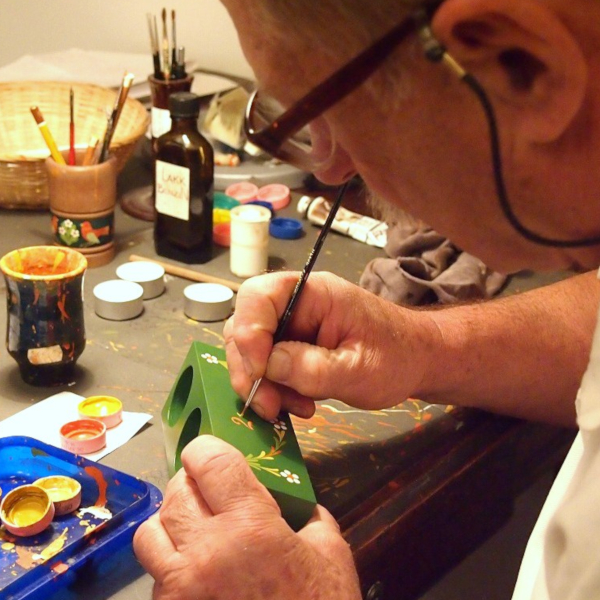 小さな木製雑貨にトールペイントを描いているハンガリーの絵付師、ホッローさん